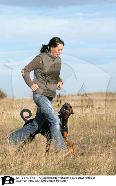Frau rennt mit Dobermann / wwoman runs with Doberman Pinscher / SS-07775