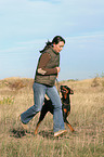 woman runs with Doberman Pinscher