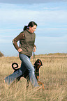 wwoman runs with Doberman Pinscher