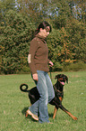 woman walks with Doberman Pinscher