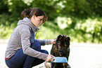 young woman feeds GDR Shepherd