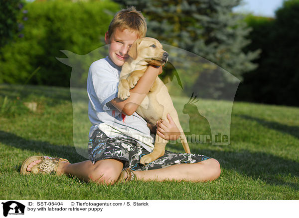 Junge und Labrador Retriever Welpe / boy with labrador retriever puppy / SST-05404