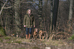 woman and 2 shorthaired Magyar Vizslas