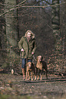 woman and 2 shorthaired Magyar Vizslas