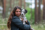 Woman carries Miniature American Shepherd