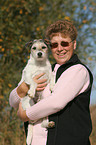 woman carries Parson Russell Terrier