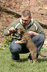 man and mongrel puppy