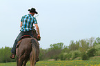 man rides American Paint Horse