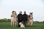 man and woman with horses and dog