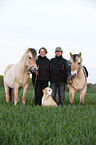 man and woman with horses and dog