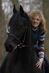 woman rides Frisian horse