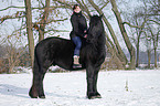 woman rides Frisian horse