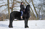 woman rides Frisian horse