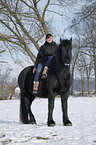 woman rides Frisian horse