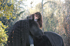 woman rides Frisian horse
