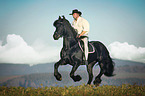 man rides Frisian horse