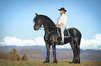 man rides Frisian horse