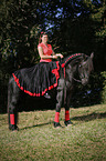 woman rides Friesian Horse