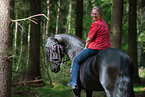 woman rides Friesian Horse