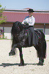 woman rides Friesian horse