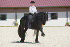 woman rides Friesian horse