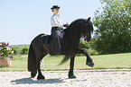 woman rides Friesian horse