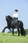 woman rides Friesian horse