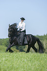 woman rides Friesian horse