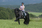 woman rides Friesian horse