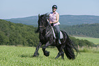 woman rides Friesian horse