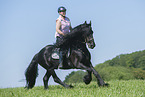 woman rides Friesian horse