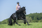woman rides Friesian horse