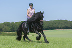 woman rides Friesian horse
