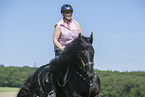 woman rides Friesian horse