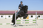 woman rides Friesian horse