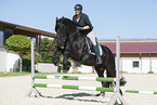 woman rides Friesian horse