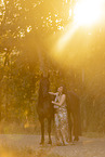 young woman with friesian mare
