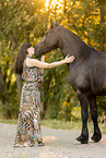 young woman with friesian mare