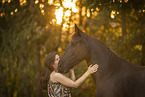young woman with friesian mare