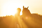 young woman with friesian mare