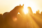 young woman with friesian mare