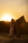 young woman with friesian mare