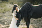 young woman in dress with frisian horse