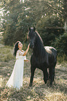 young woman in dress with frisian horse