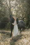 young woman in dress with frisian horse