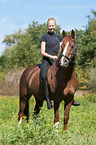 woman rides German Riding Pony
