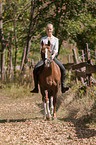 woman rides German Riding Pony