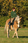 woman rides haflinger horse