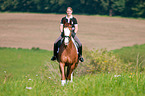 woman rides Hessian Warmblood
