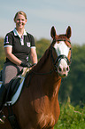 woman rides Hessian Warmblood